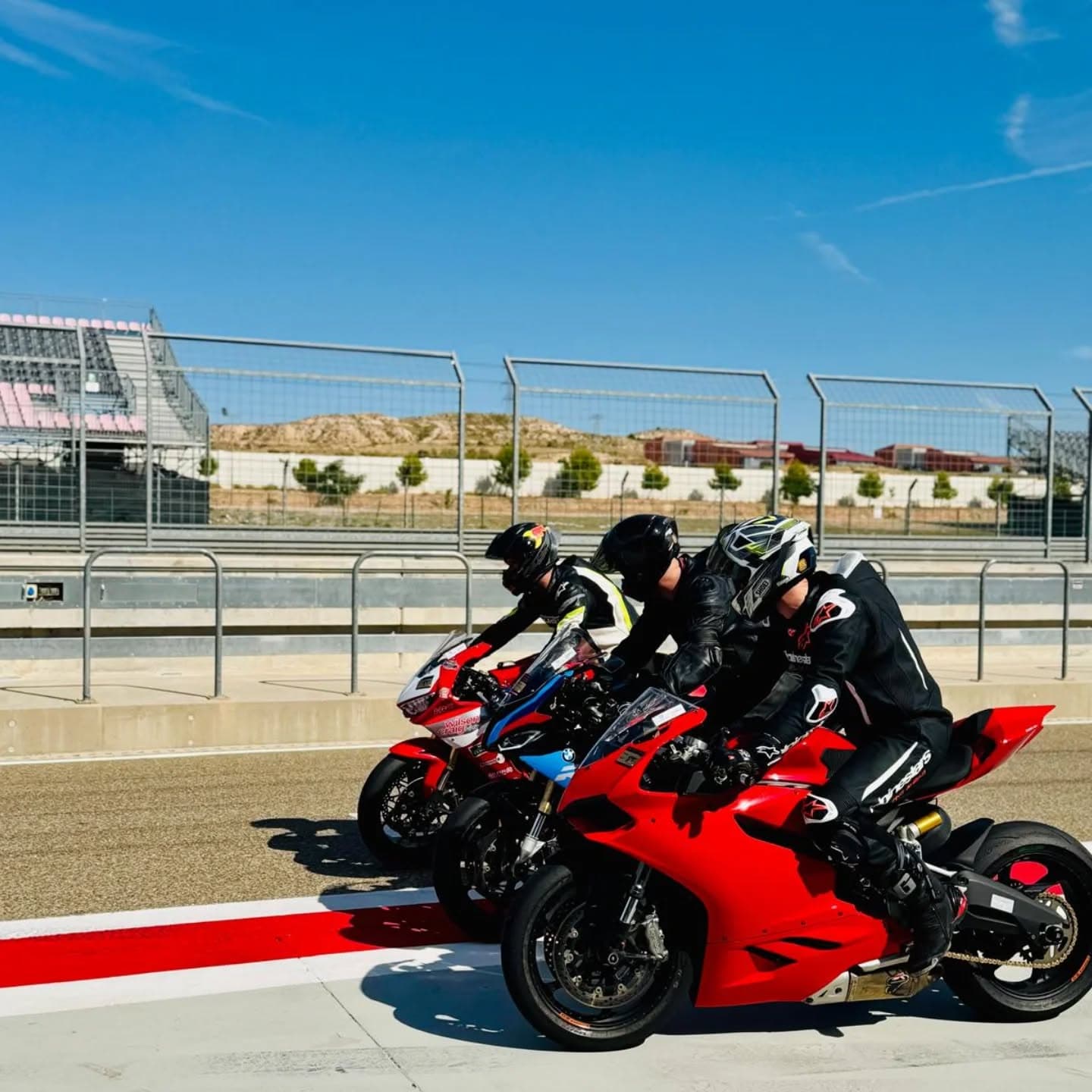 Motorcycles lined up in the pit lane at a UK track day